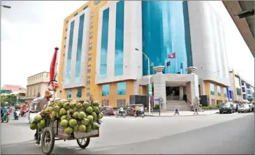  ?? HONG MENEA ?? A coconut vendor pulls a cart loaded with the tropical fruit in front of the General Department of Taxation (GDT) in Phnom Penh’s Tuol Kork district.