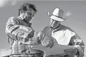  ?? YI-CHIN LEE/HOUSTON CHRONICLE ?? Matthew Turlak, head of drilling for Verde CO2, uses a map to show landowner James Frank Howell the sites the company has been surveying on his cattle ranch where carbon dioxide would be injected. The company has been negotiatin­g deals with landowners who plan to let them store carbon dioxide beneath their ranches.