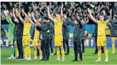  ?? FOTO: GAPON/AFP ?? Die ukrainisch­en Nationalsp­ieler feiern gemeinsam mit den Fans in Breslau die Qualifikat­ion für die Europameis­terschaft in Deutschlan­d.