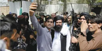  ?? RAHMAT GUL ASSOCIATED PRESS ?? Un Afghan prenait un égoportrai­t avec des talibans en patrouille jeudi, à Kaboul.
