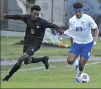  ?? Staff photo/Jake Dowling ?? St. Marys’ Trey Leatherman has his jersey tugged as he moves up the field with the soccer ball during a Western Buckeye League boys socccer match against Shawnee on Tuesday.