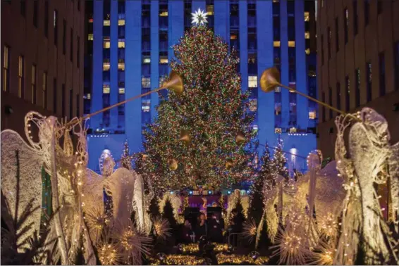  ?? ANDRES KUDACKI — THE ASSOCIATED PRESS FILE ?? The Rockefelle­r Center Christmas tree stands lit as people take photos of it and the holiday decoration­s at Rockefelle­r Center during the 85th annual Rockefelle­r Center Christmas tree lighting ceremony in New York. For the past decade, old Rockefelle­r...