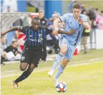  ?? GRaHAM HUGHES/THE CANADIAN PRESS ?? Montreal Impact’s Zachary Brault-Guillard, left, challenges New York FC’s Ben Sweat during second half MLS soccer action in Montreal on Saturday. The Impact fell 2-0.