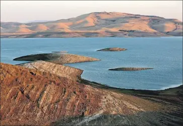  ?? Gary Coronado Los Angeles Times ?? CALIFORNIA’S massive federal irrigation system, the Central Valley Project, must comply with the Endangered Species Act, state environmen­tal regulation­s and water rights permits. Above, the San Luis Reservoir.