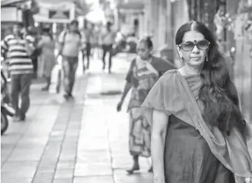  ??  ?? Rajani walking to her office in Mumbai. — AFP photos