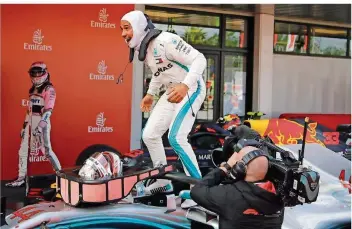  ?? FOTO: MORENATTI/AP/DPA ?? Lewis Hamilton ist nach seinem Sieg in Barcelona auf den Boliden gestiegen und springt im nächsten Moment seinem Team entgegen. Der zweite Sieg in Serie beflügelt den Briten.