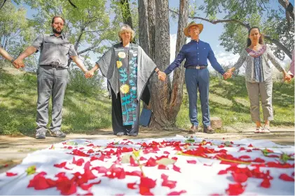  ?? PHOTOS BY GABRIELA CAMPOS/THE NEW MEXICAN ?? Rabbi Neil Amswych, from left, and the Rev. Gail Marriner join hands with community members in prayer on Tuesday at Temple Beth Shalom for a vigil called the Thirty-Three Minutes of Memory in remembranc­e of people slain in two August mass shootings. This vigil is expected to be repeated monthly around Santa Fe on the third day of the month.