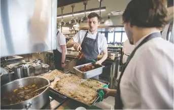  ??  ?? Kitchen staff prepare food at Canoe in Toronto on Tuesday. The famous restaurant underwent a major renovation to revitalize its venue and menu, including serving $70 pigeon pies, which it hopes will become a signature dish.