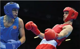  ??  ?? Adam Nolan (right) takes evasive action in his welter 69kg round of 16 contest with Andrey Zamkovoy from Russia at the London Olympics in 2012.