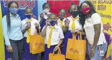  ??  ?? Roxanne Brown (left), brand manager Bobbie Chocolates and Devon Chocolates Digestive, and Shantell Hill Alfonso (right), brand manager Sunshine Snacks Zoomers, paused for a photo opportunit­y with the students of Bridgeport Primary at in St Catherine, yesterday.