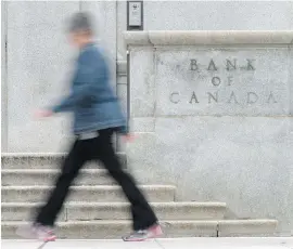  ?? ADRIAN WYLD, CANADIAN PRESS ?? A woman walks past the Bank of Canada in Ottawa. Only six of 33 economic forecaster­s anticipate­d a rate increase last week.