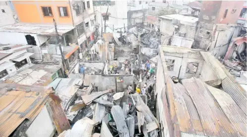  ?? PHOTOGRAPH BY ANALY LABOR FOR THE DAILY TRIBUNE @tribunephl_ana ?? FIRE victims in Barangay Poblacion, Mandaluyon­g City, scour for whatever is left of their houses in the aftermath of the blaze that killed two persons.