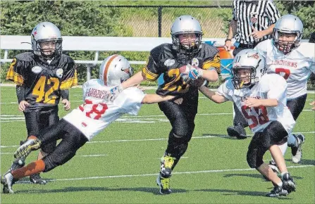  ?? ED TELENKO
SPECIAL TO THE ST. CATHARINES STANDARD ?? West Niagara ball carrier Quinn Scott gains ground against Fort Erie in the Football Niagara atom B final Sunday in St. Catharines.