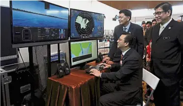  ??  ?? Going high-tech: Liow being briefed by Maritime Department director-general Datuk Baharin Abdul Hamid while Transport Ministry deputy secretary-general Datuk Chua Kok Ching (right) looks on at the launch of Malaysia World Maritime Week 2017 in Kuala...