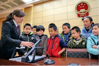  ?? Cnsphoto ?? 26 de febrero de 2016. Una empleada del Tribunal Popular Intermedio de la ciudad de Qinhuangda­o, provincia de Hebei, le habla a los niños de una escuela primaria sobre sus experienci­as, de algunos conceptos de su profesión y de la necesidad de ser...