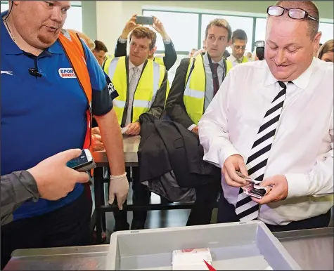  ??  ?? Loose change: Mike Ashley empties his pockets yesterday And there’s more: The Sports Direct tycoon pulls out £50 after £50, placing the crumpled notes in a security tray