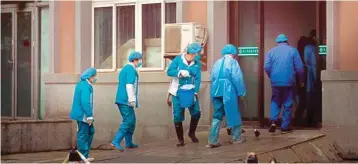  ?? PIC/PTI ?? Hospital staff wash the emergency entrance of Wuhan Medical Treatment Center, where some infected with a new virus are being treated, in Wuhan, China