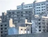  ??  ?? NOBODY HOME: Abandoned buildings line the sea wall-encircled island with a dark past.