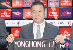  ??  ?? NEW ERA: Chinese businessma­n Li Yonghong poses with an AC Milan jersey during a press conference in Milan on Friday.