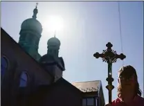  ?? Carolyn Kaster / Associated Press ?? Joshua Wisotski carries the crucifix as he leads the congregati­on for the procession of the Holy Shroud on Good Friday at Transfigur­ation Of Our Lord Ukrainian Catholic Church, in Shamokin, Pa.,Friday.