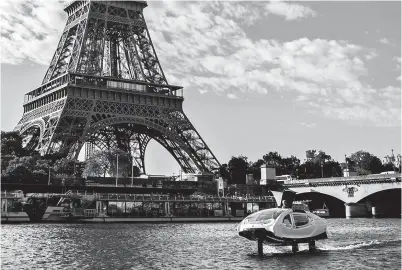  ??  ?? An electric boat, the “Sea Bubble” “flying taxi,” cruises on the river Seine with the Eiffel Tower in the background during a test in Paris yesterday. — AFP