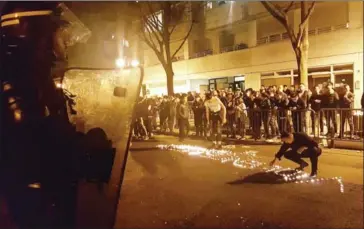  ?? SONIA BAKARIC/AFP ?? Youths use candles to write the word ‘Violence’ in the road in front of a line of riot police outside the commisaria­t of the 19th Arrondisse­ment of Paris late on Monday, during clashes in the wake of the death of a Chinese national during a police...