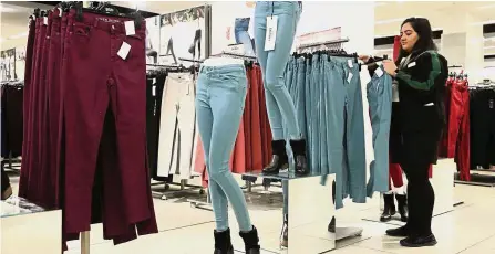  ??  ?? Downsizing operations: An employee arranges pairs of skinny jeans in an M&S outlet in London. The retailer plans to shut nearly one-third of its large stores in UK. — Bloomberg