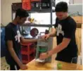  ??  ?? POTTSTOWN JUNIORS Asgar Ali and Shane Duncan demonstrat­e a fruit slicer they created that won the “DOW WE Are Innovators Challenge” and a trip to Ecuador this summer with engineerin­g teacher/advisor Andy Bachman.