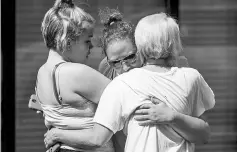  ?? —AFP photo ?? People console each other outside the Burnette Chapel Church of Christ.