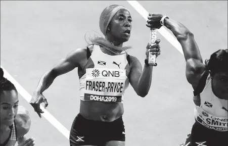  ?? AP ?? Jamaica’s Shelly-Ann Fraser-Pryce passes the baton during a relay race at the 2019 world championsh­ips in Doha, Qatar.