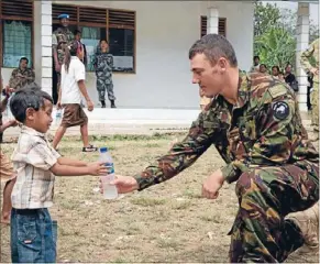  ??  ?? Thirsty work: Private Jurie Bender making friends while on deployment to Timor-Leste.