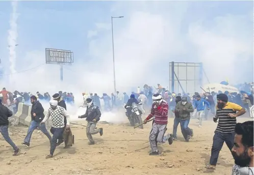  ?? ?? Indian farmers run for cover as police fire tear gas, with prime minister Narendra Modi, below, likely to placate protests ahead of an election