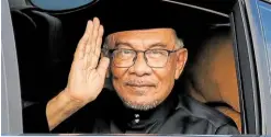  ?? —AFP ?? THREE-DECADE JOURNEY Malaysia’s newly appointed Prime Minister Anwar Ibrahim waves from his car as he arrives for the swearing-in ceremony at the National Palace in Kuala Lumpur on Thursday.