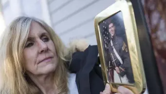  ?? NICOlAuS CzARnECkI / HERAlD StAFF ?? FIGHTING ON: Kim Brooks holds a photograph of her late husband, Lt. Col. Timothy P. Brooks, outside her home in Norwood. Timothy Brooks died of cancer on May 29, 2004, after serving in a toxic environmen­t in Uzbekistan.