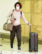  ?? MARK BAKER AP ?? A passenger arrives at Sydney Airport on Monday, a day after Australian authoritie­s said that two travelers who arrived from Africa were the first in the country to test positive for the omicron variant.