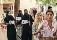  ?? PTI ?? Voters show their ID cards as they wait in a queue to cast their votes during the Uttar Pradesh Assembly by-polls, at cantonment area in Lucknow, Monday