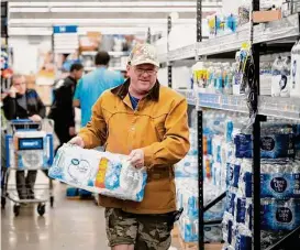  ?? Mark Mulligan/Staff photograph­er ?? John Beezley of Bonham buys water in a Houston Walmart on Sunday after learning that a boil water notice was issued for the city. Beezley had just arrived in town with his wife, who is receiving medical treatment.