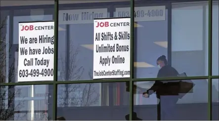  ?? CHARLES KRUPA — THE ASSOCIATED PRESS FILE ?? A woman walks past the signs of an employment agency in Manchester, N.H.