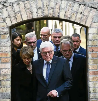  ?? FOTO: HENDRIK SCHMIDT/DPA ?? Bundespräs­ident Frank-Walter Steinmeier (M.) besucht mit seiner Frau Elke Büdenbende­r und Sachsen-Anhalts Ministerpr­äsident Reiner Haseloff den Tatort an der Synagoge.