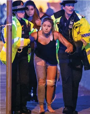  ??  ?? Horror attack: Police help a victim of the Manchester bomb