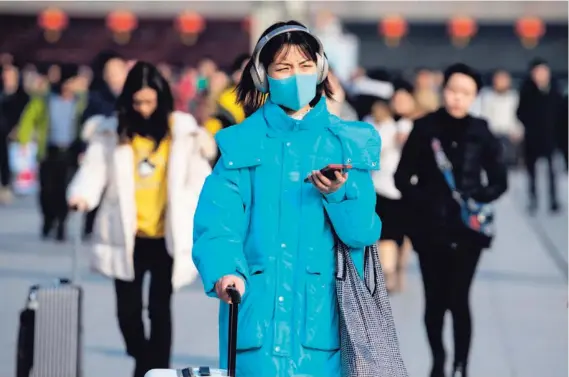  ?? AFP ?? Los peatones en la capital japonesa ya caminan con mascarilla­s para evitar posibles contagios.