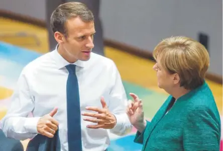  ?? Stephanie Lecocq, The Associated Press ?? French President Emmanuel Macron speaks with German Chancellor Angela Merkel in June at a European Union summit in Brussels.