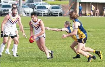  ?? ?? Dusties player Johnathan Miron bursts away from would-be tacklers from Inverloch-Kongwak in the reserves match.