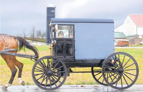  ?? JOSE F.MORENO/THE PHILADELPH­IAINQUIRER/TNS FILE PHOTOS ?? A couple of Amish children look out the window of a horse-drawn cart during a rainy day ride along Old Philadelph­ia Pike in Gordonvill­e, Lancaster County, Pennsylvan­ia, in March 2020.