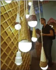  ??  ?? A waffle light wall featuring a series of hanging ice cream cones light bulbs is among ice cream-themed works of art previewed at the Museum of Ice Cream, Thursday in New York. It opens on Friday and runs through Aug. 31.