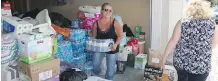  ?? CHELSEA KEMP/ AIRDRIE ECHO ?? Karen Drapper, right, and Mireille Evans load supplies for people displaced by the B.C. fires in Calgary on July 20.