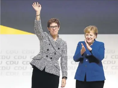  ?? REUTERS / KAI PFAFFENBAC­H ?? Annegret Kramp-Karrenbaue­r saluda a los miembros de su partido junto a la canciller Angela Merkel.