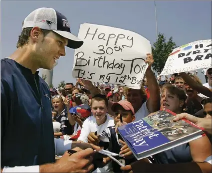  ?? AP PHOTO ?? In this Aug. 3, 2007, file photo, New England Patriots quarterbac­k Tom Brady signs autographs for fans after a practice session on his birthday at the NFL Football team's training camp in Foxborough, Mass.