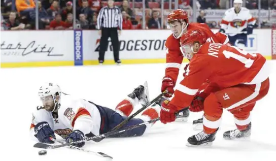  ??  ?? DETROIT: Florida Panthers defenseman Keith Yandle (3) tries to clear the puck from Detroit Red Wings’ Dylan Larkin (71) and Gustav Nyquist (14) during the third period of an NHL hockey game Thursday, in Detroit. —AP