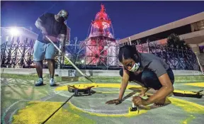  ?? MICKEY WELSH/USA TODAY NETWORK ?? Volunteers paint Black Lives Matter around a fountain in Montgomery, Ala., as a Juneteenth Art on the Square project in 2020.